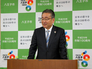 記者会見でサービス開始を発表する石森孝志八王子市長.jpg